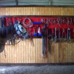 DIY horse tack board holding saddles.