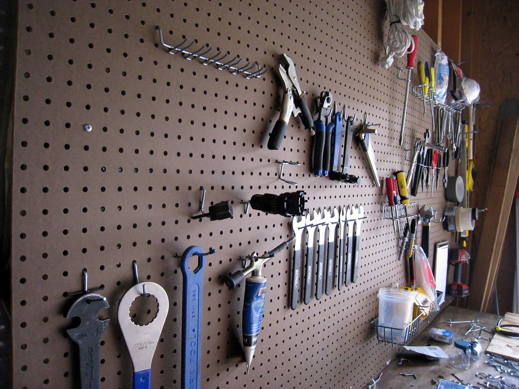 A pegboard that is holding tools.