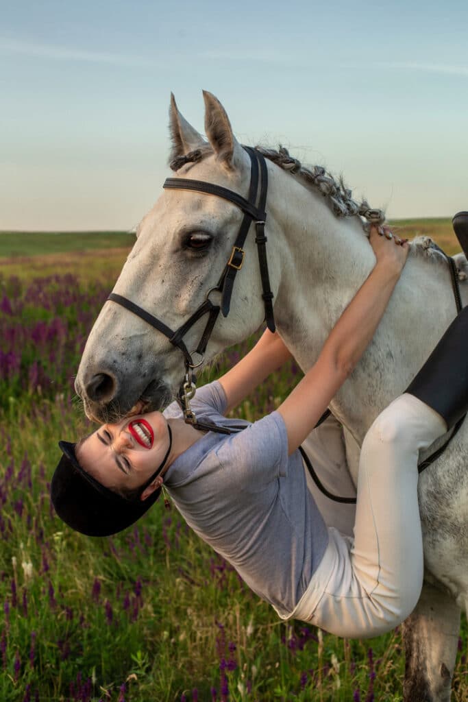 Girl hanging onto horse.